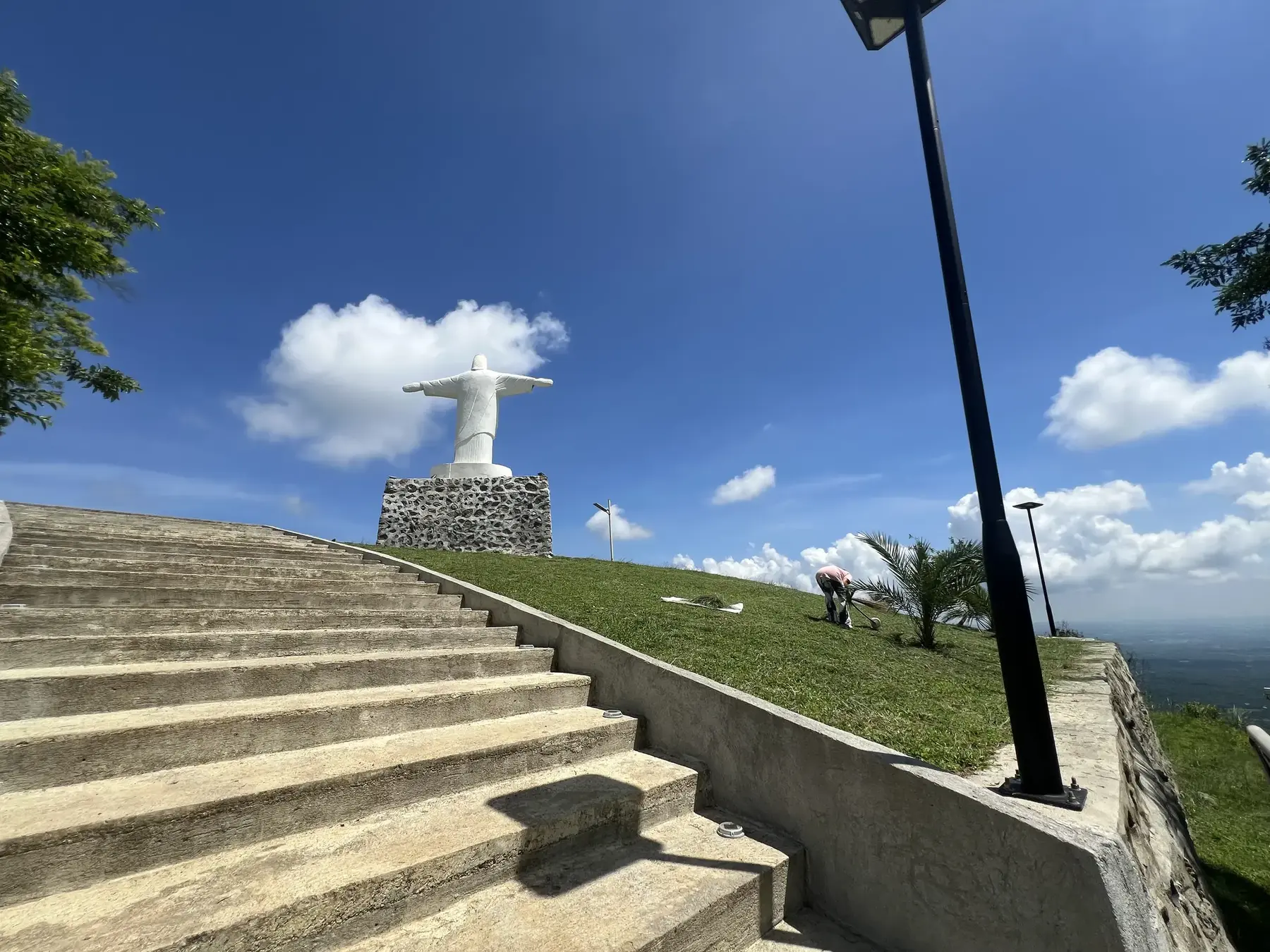 The Monte Cristo hilltop deck with stone picnic tables and a solar lamp, overlooking the graded road below